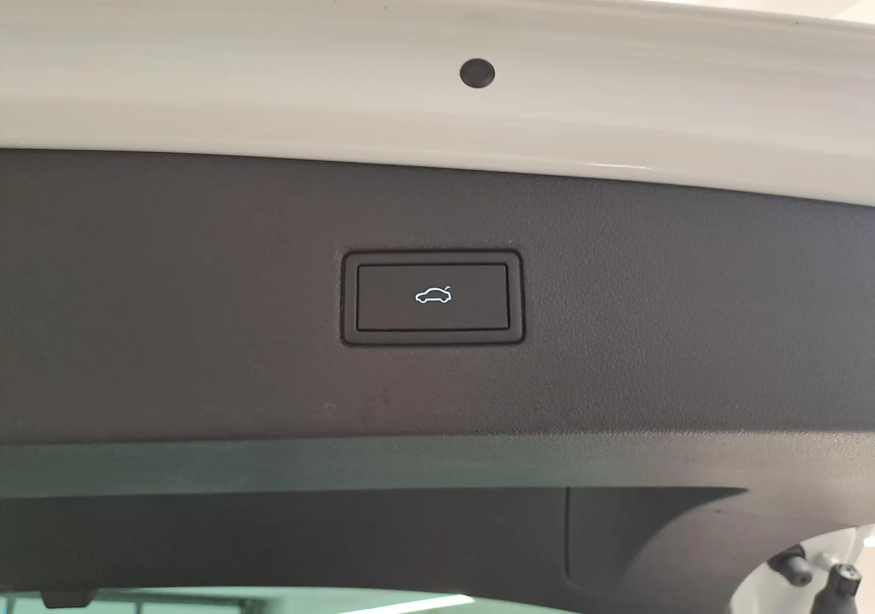 Bouton d'ouverture électrique du coffre sur la partie intérieure du hayon blanc pur d'un Volkswagen Tiguan 2023.