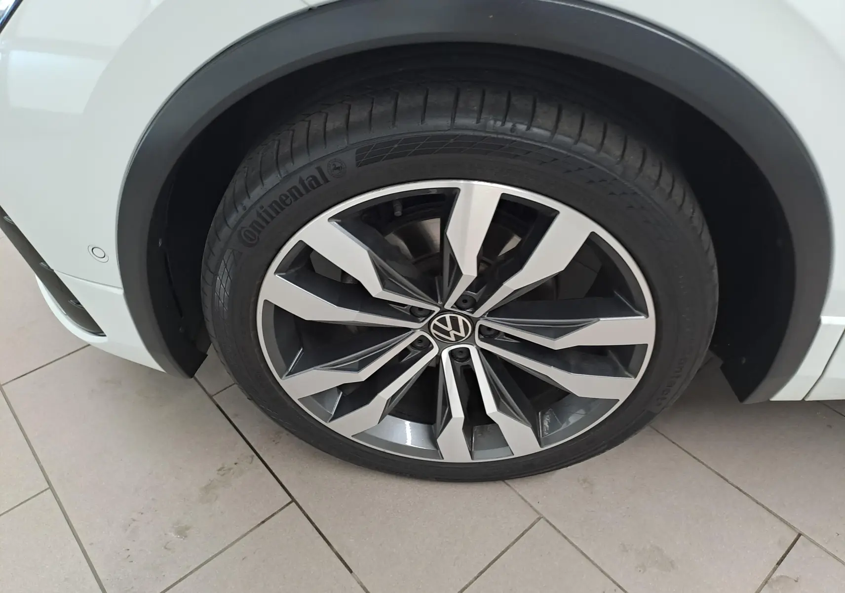 Gros plan sur la jante alliage 20'' Suzuka noire et argent du Volkswagen Tiguan blanc pur, côté avant droit.