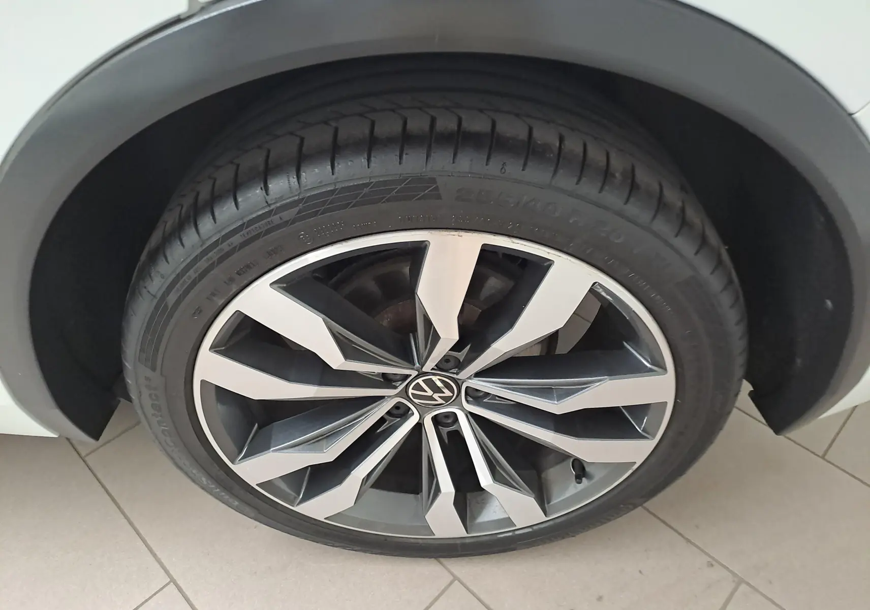 Gros plan sur la jante alliage 20'' Suzuka bicolore du Volkswagen Tiguan blanc pur, pneu 255/40 R20 visible.