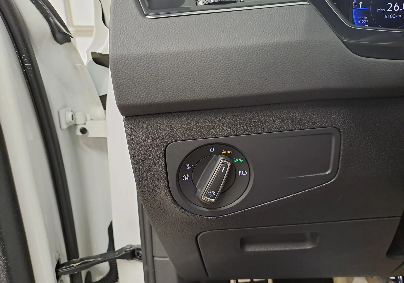 Gros plan sur le bouton de commande des phares à gauche du tableau de bord d'un Volkswagen Tiguan blanc pur 2023.