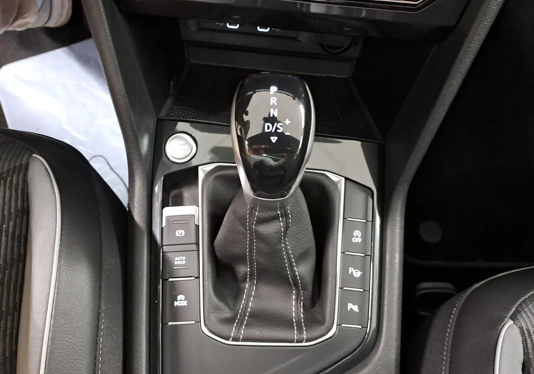 Vue rapprochée de la console centrale du Volkswagen Tiguan 2023, avec levier de vitesse DSG7 et boutons de contrôle autour.