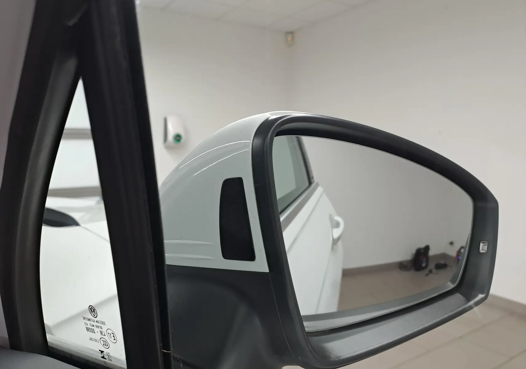 Rétroviseur extérieur droit blanc du Volkswagen Tiguan 2023, vue rapprochée avec reflet de la porte arrière.