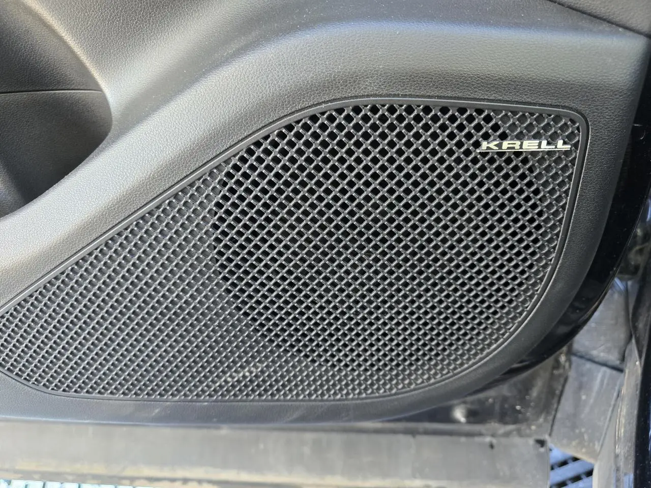 Gros plan sur le haut-parleur Krell intégré à la porte côté gauche du Hyundai Tucson noir Phantom Metal.