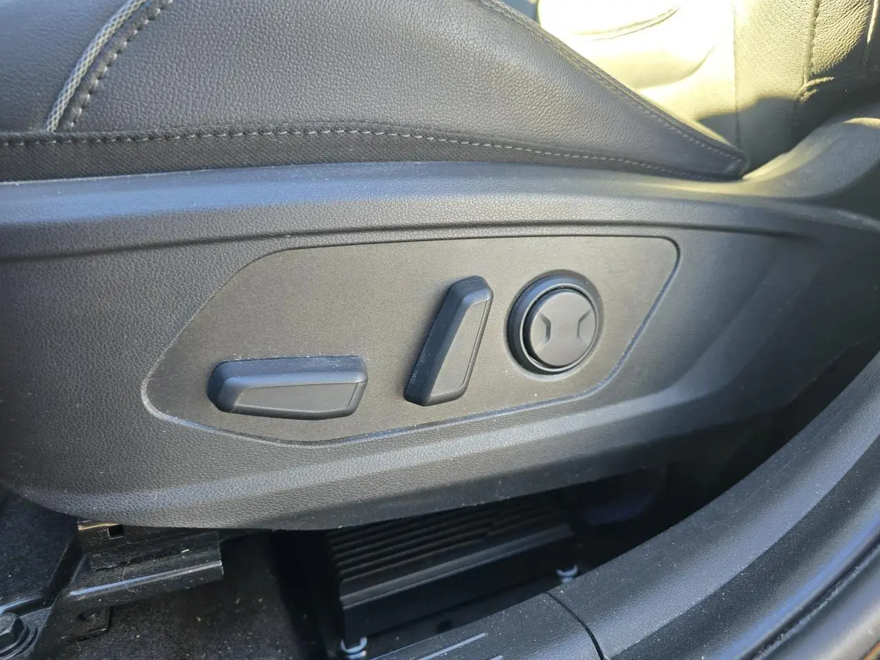 Gros plan sur les commandes électriques de réglage du siège conducteur en cuir noir du Hyundai Tucson 2021.