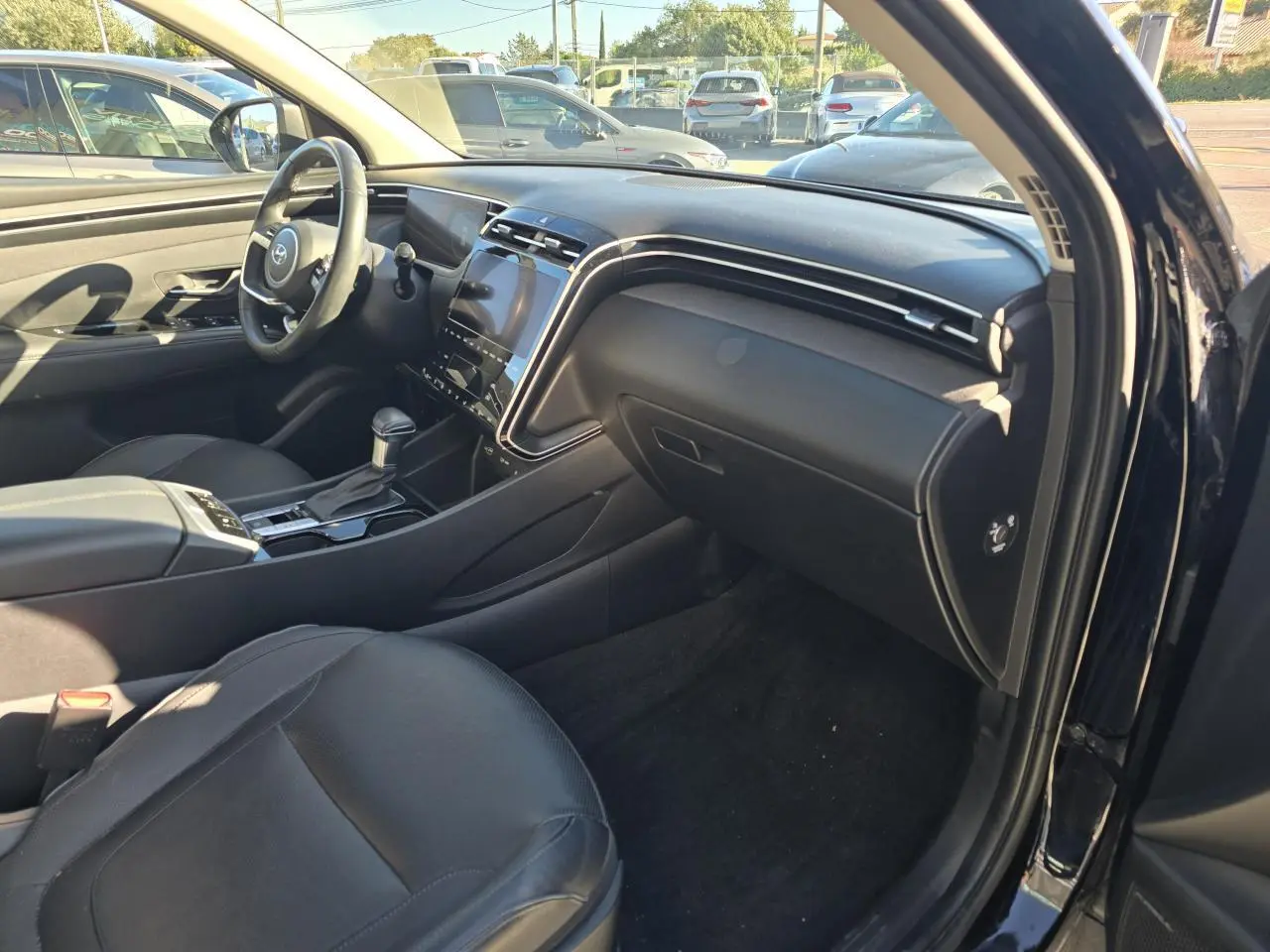 Vue intérieure côté passager du Hyundai Tucson noir Phantom Metal 2021, mettant en valeur le tableau de bord et la sellerie cuir noire.