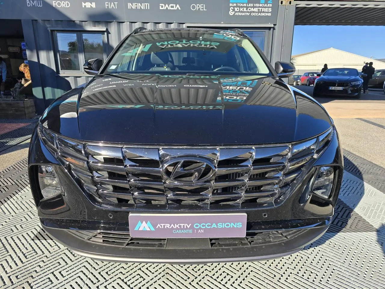 Vue frontale du Hyundai Tucson noir Phantom Metal avec calandre chromée et projecteurs bi-LED visibles.