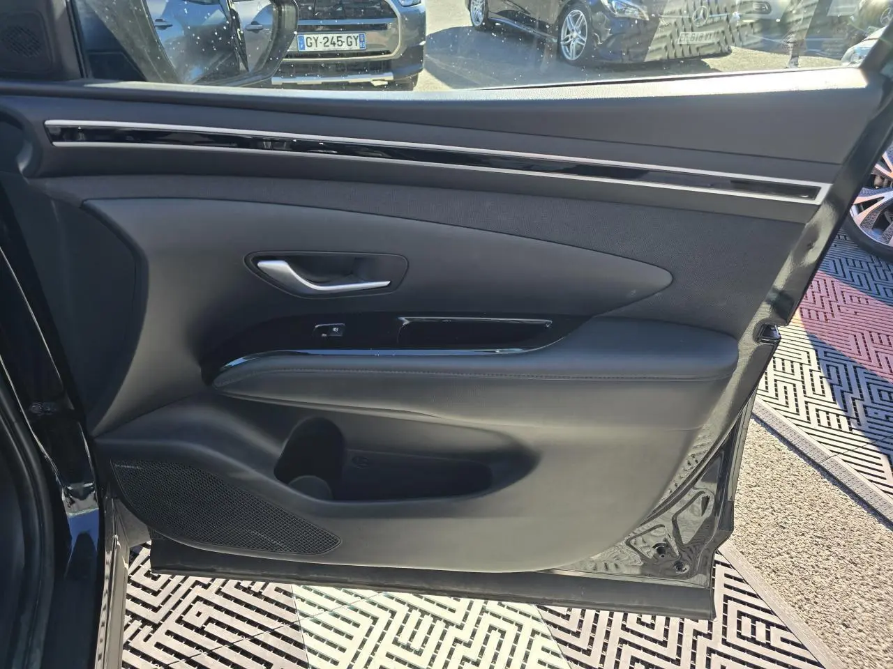 Vue rapprochée de la porte avant gauche noire Phantom Metal du Hyundai Tucson 2021 avec garniture intérieure en cuir et insert brillant.