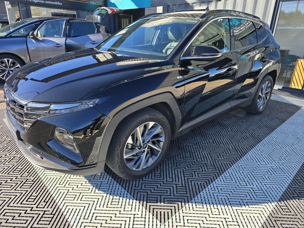 Hyundai Tucson noir Phantom Metal vu en 3/4 avant droit, avec jantes alliage et toit panoramique visible.