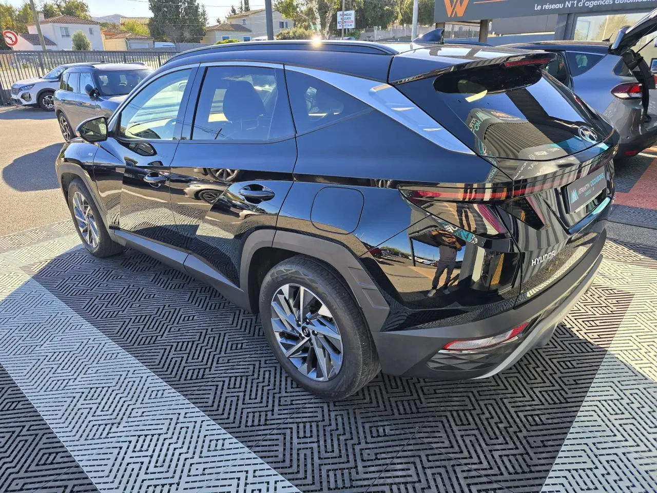 Vue 3/4 arrière droite d’un Hyundai Tucson noir Phantom Metal avec jantes alliage et toit panoramique visible.