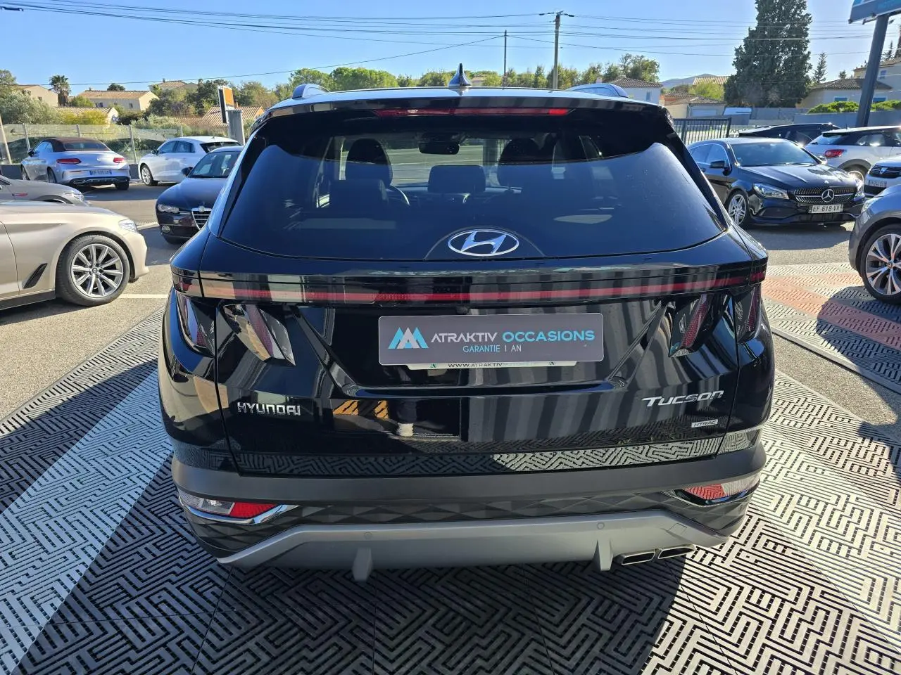 Vue arrière d'un Hyundai Tucson noir Phantom Metal avec feux arrière reliés et double sortie d'échappement visible.