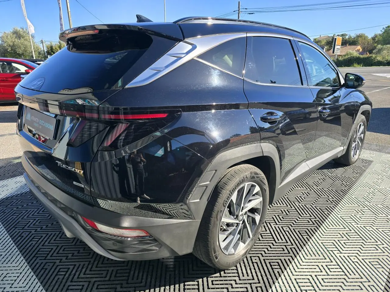 Vue 3/4 arrière droite du Hyundai Tucson noir Phantom Metal avec feux arrière LED fins et jantes alliage modernes.