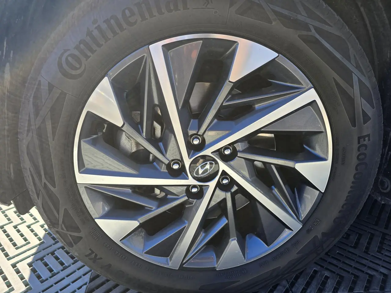 Gros plan sur la jante alliage au design géométrique du Hyundai Tucson noir Phantom Metal, avec pneu Continental.