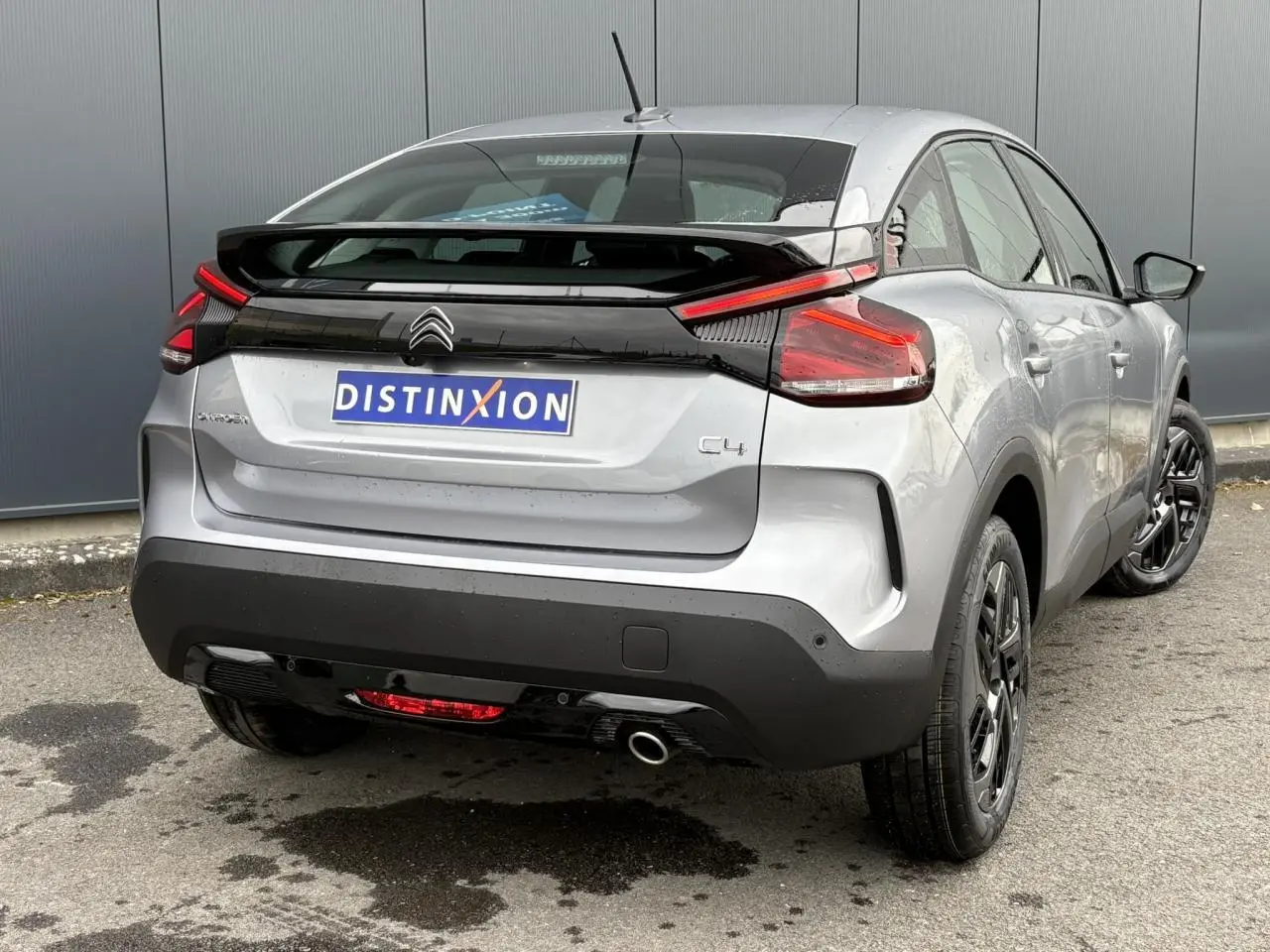 Vue 3/4 arrière droite d'une Citroën C4 gris acier avec feux arrière LED et jantes alliage noires.