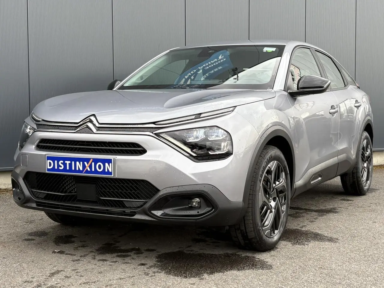 Citroën C4 gris acier vue 3/4 avant droit, avec phares LED et jantes alliage noires diamantées.