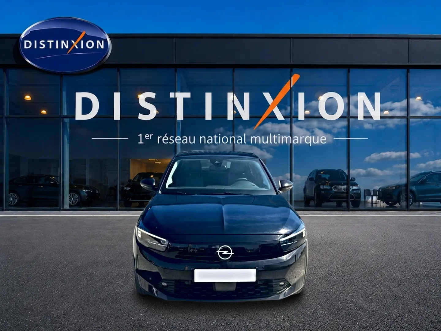 Opel Corsa 1.2 turbo noir vue de face, avec calandre noire brillante et phares LED devant showroom Distinxion.
