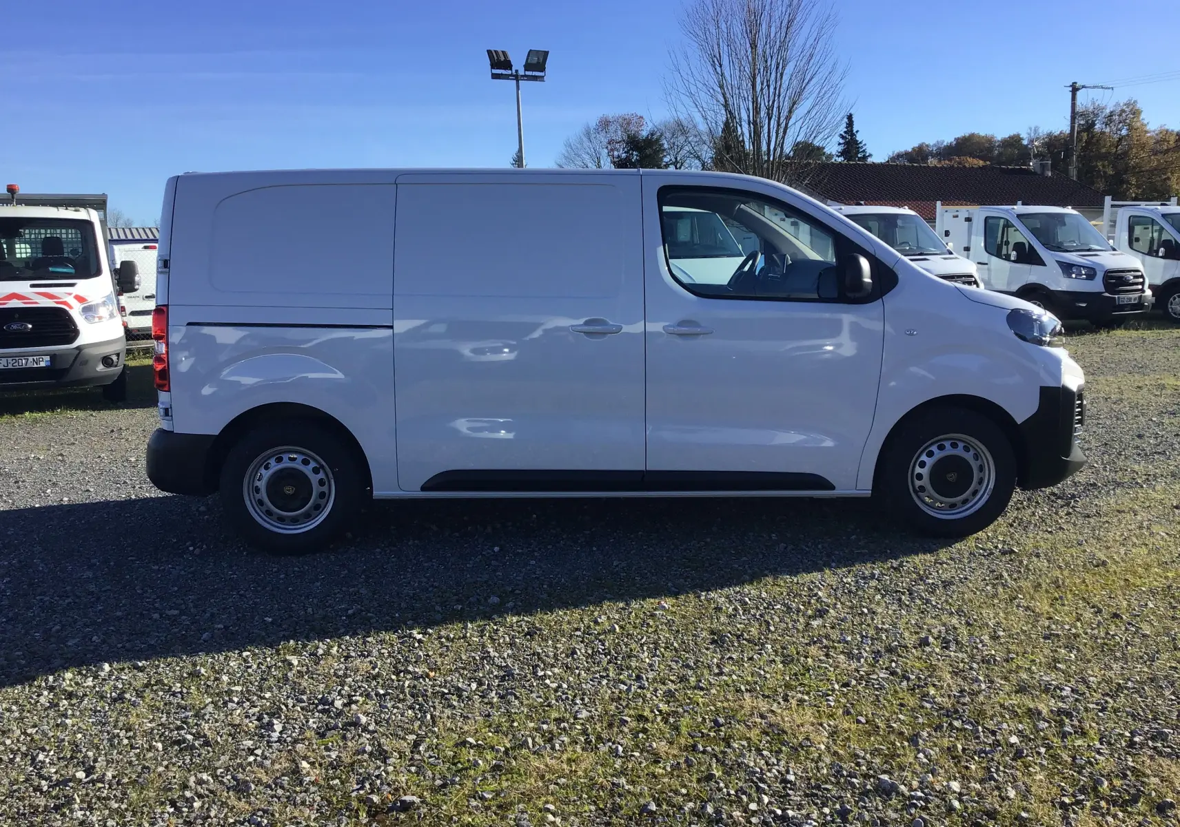 Profil côté gauche d'un Peugeot Expert Fourgon blanc 2024, avec porte coulissante et jantes acier simples.