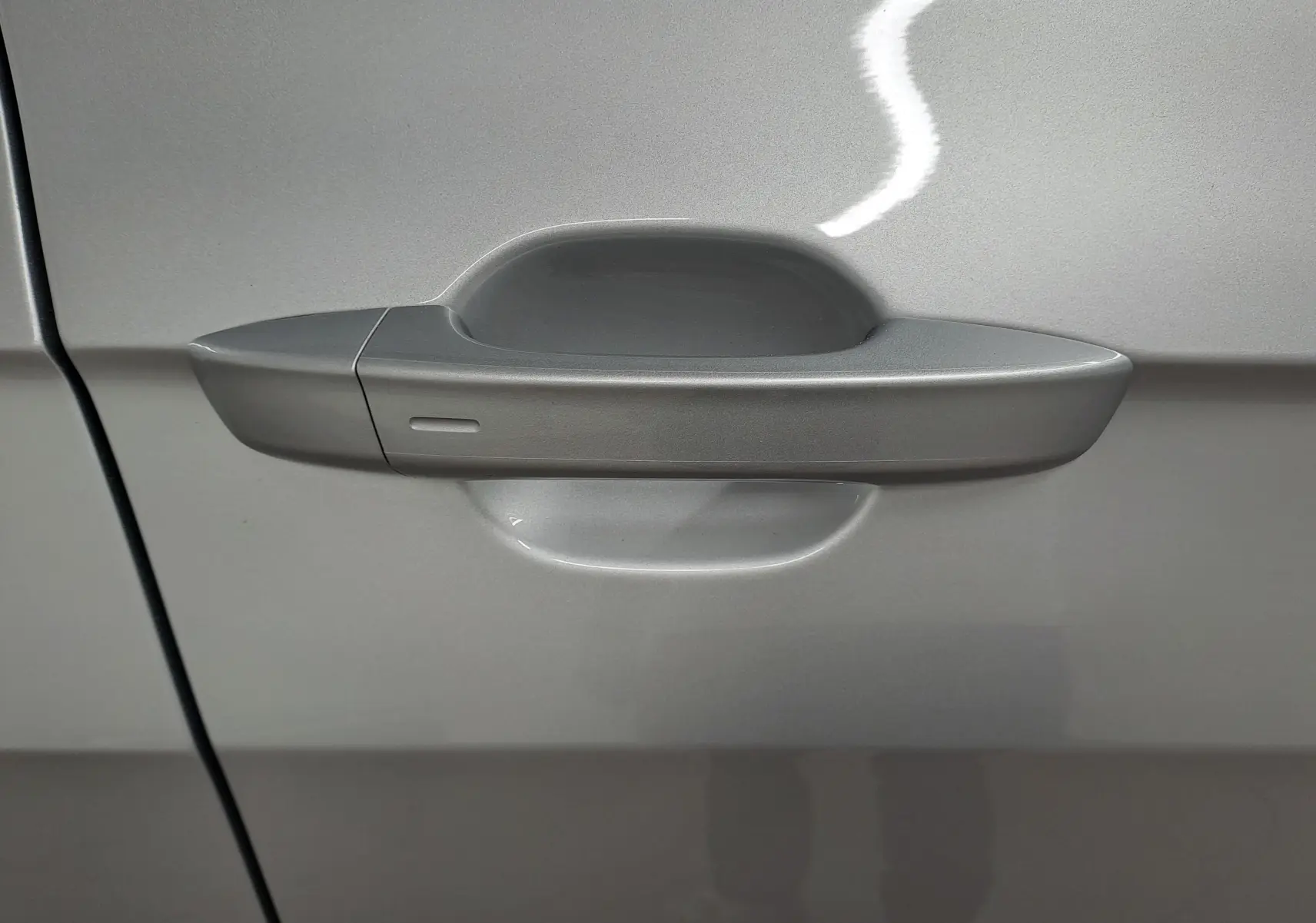 Poignée de porte côté gauche du Volkswagen T-Cross 2025 en peinture métallisée Reflet d'argent.