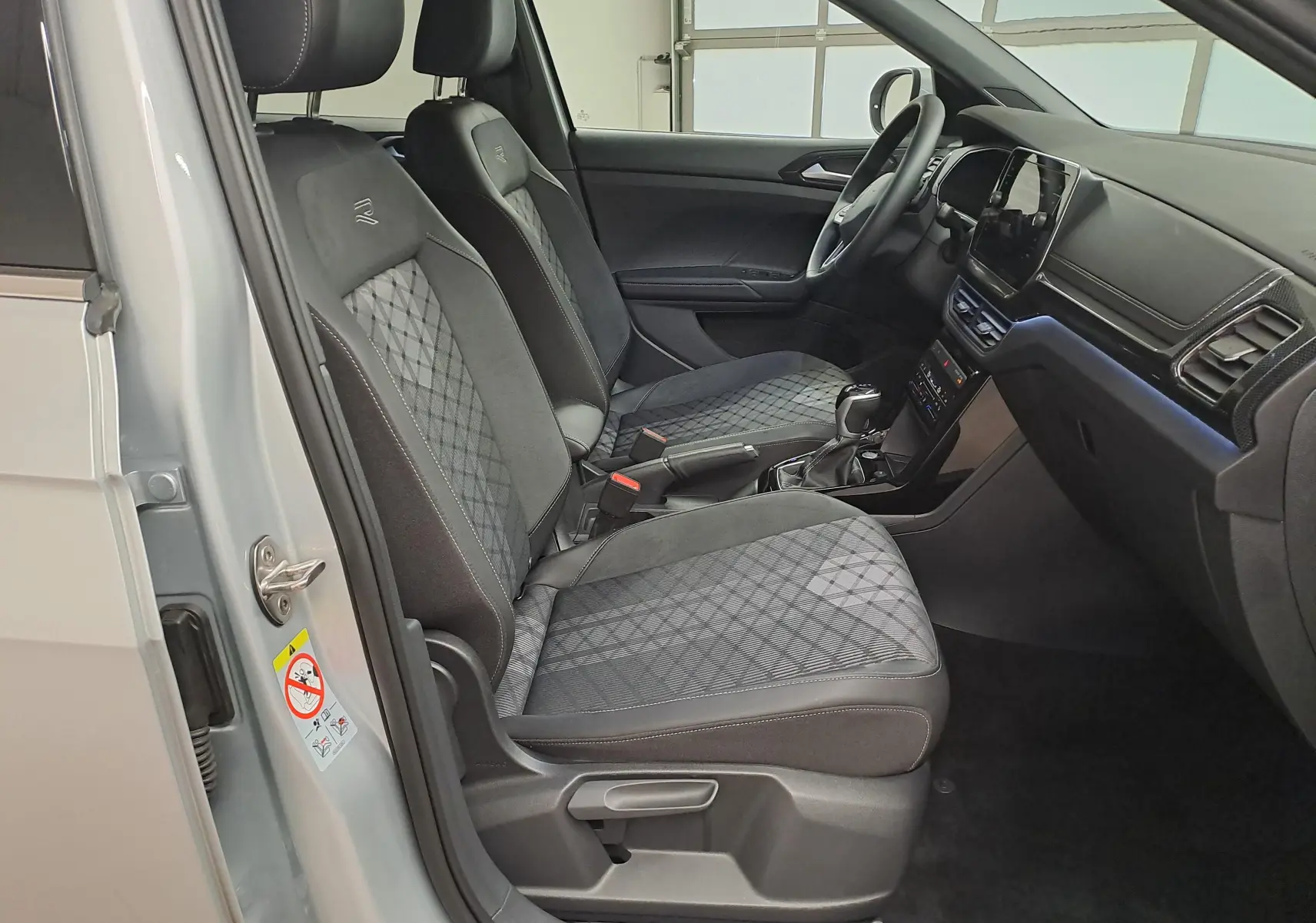 Vue intérieure côté gauche du Volkswagen T-Cross 2025 argent avec sièges avant chauffants et finition R-Line.
