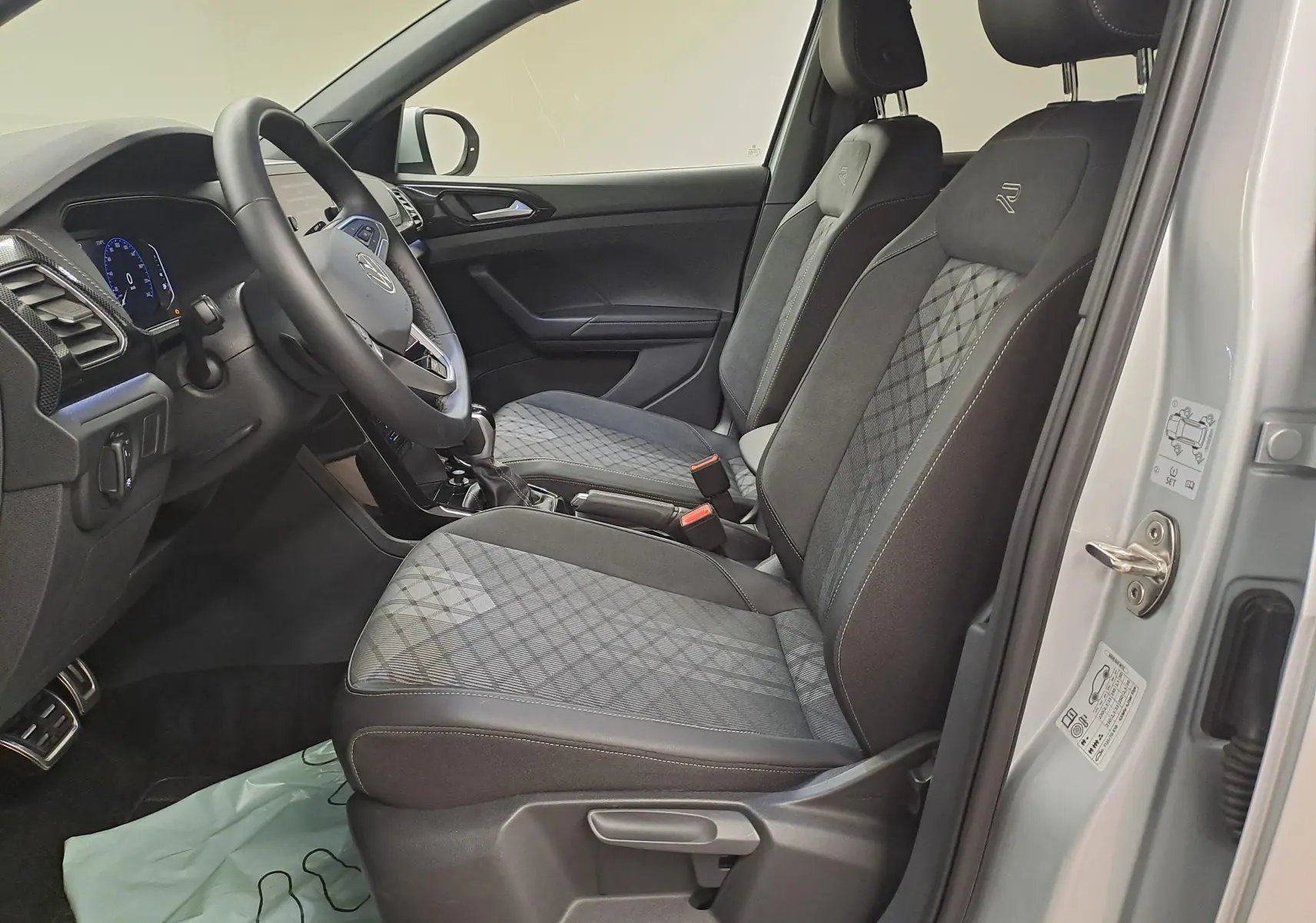 Vue intérieure côté conducteur du Volkswagen T-Cross 2025 argent, sièges avant chauffants avec surpiqûres R-Line.