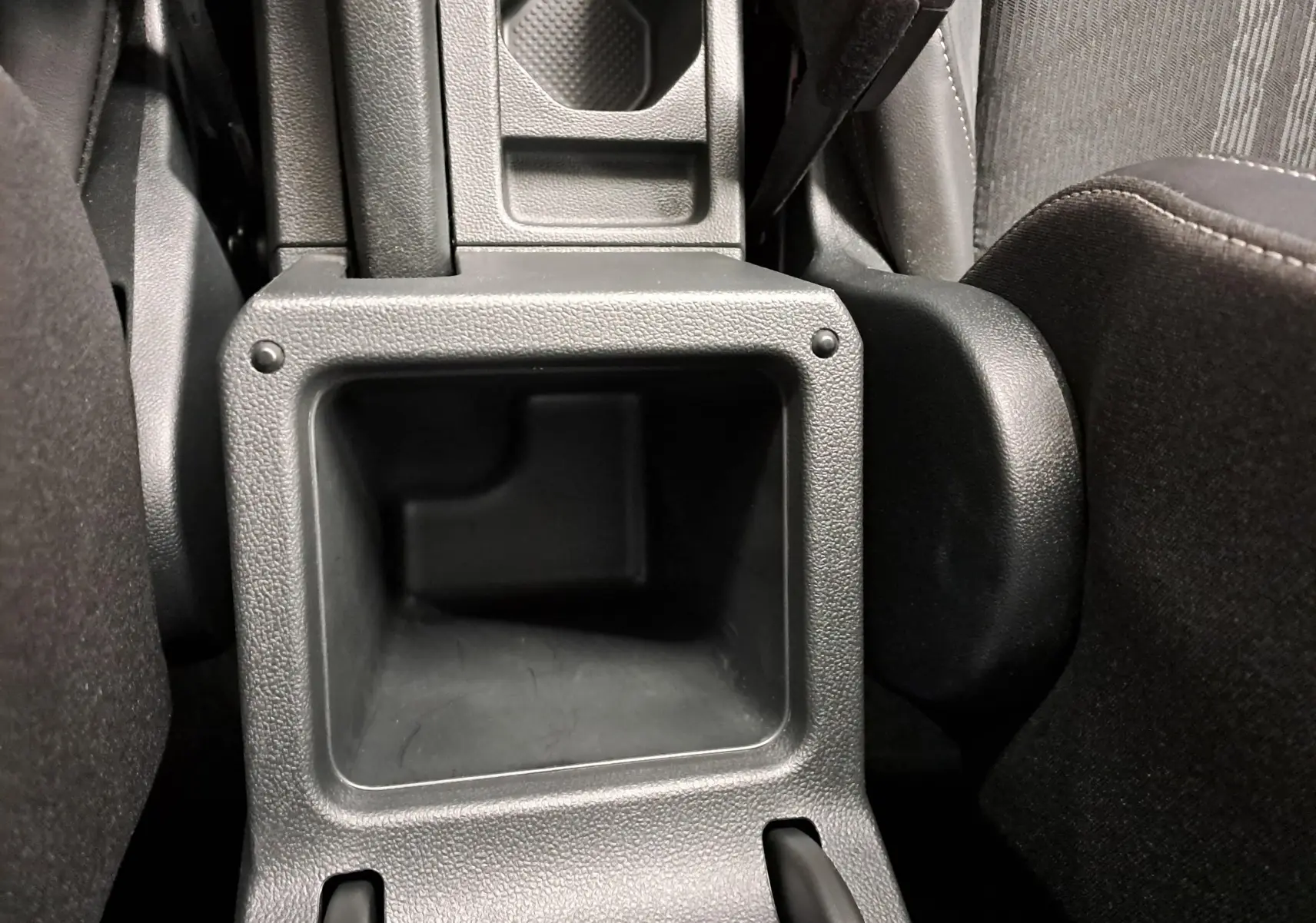 Gros plan sur le rangement central arrière en plastique noir du Volkswagen T-Cross 2025, finition R-Line Edition.