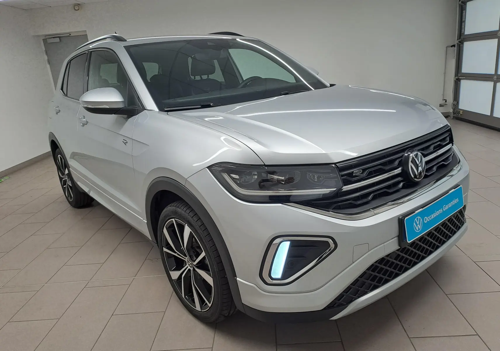 Volkswagen T-Cross 2025 argent Reflet d'argent en 3/4 avant droit avec jantes alliage et feux LED allumés.