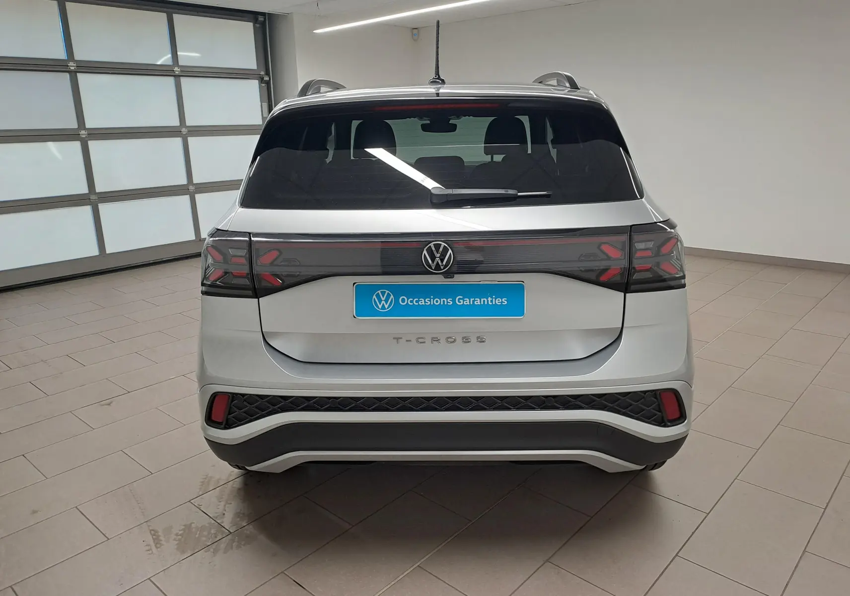 Vue arrière du Volkswagen T-Cross 2025 en Reflet d'argent, avec feux arrière LED et logo VW central visible.