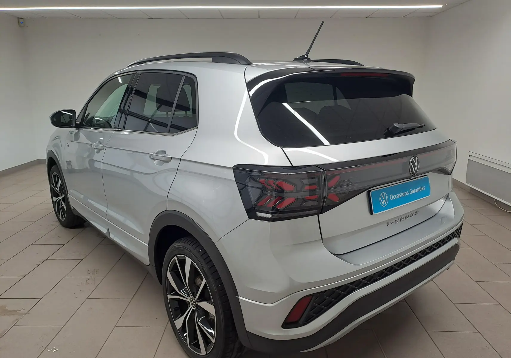 Vue 3/4 arrière droite du Volkswagen T-Cross 2025 en Reflet d'argent avec jantes alliage 18'' et feux arrière LED noirs.