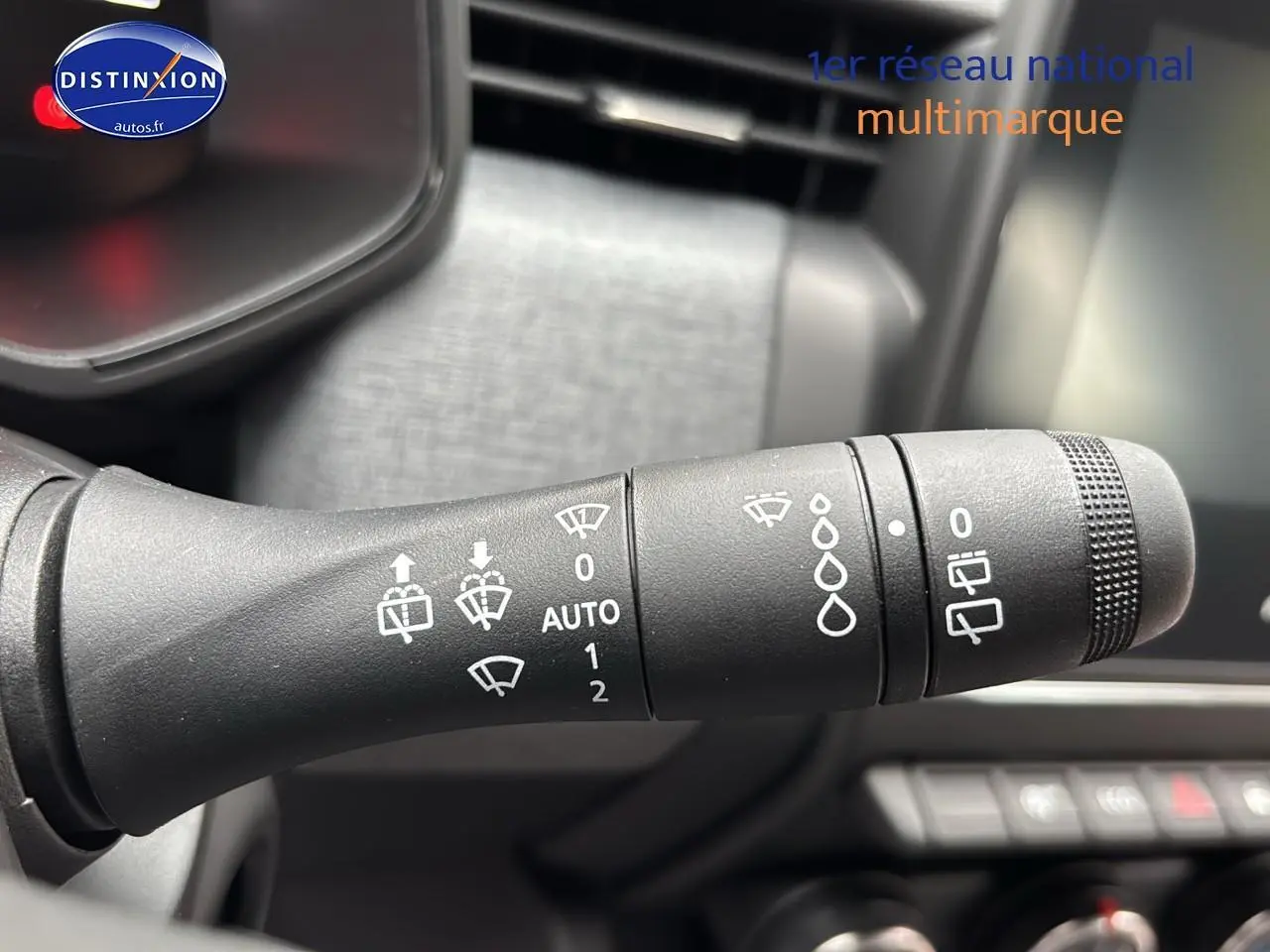 Gros plan sur la commande d’essuie-glace du côté gauche dans l’habitacle d’une Renault Clio V noire.