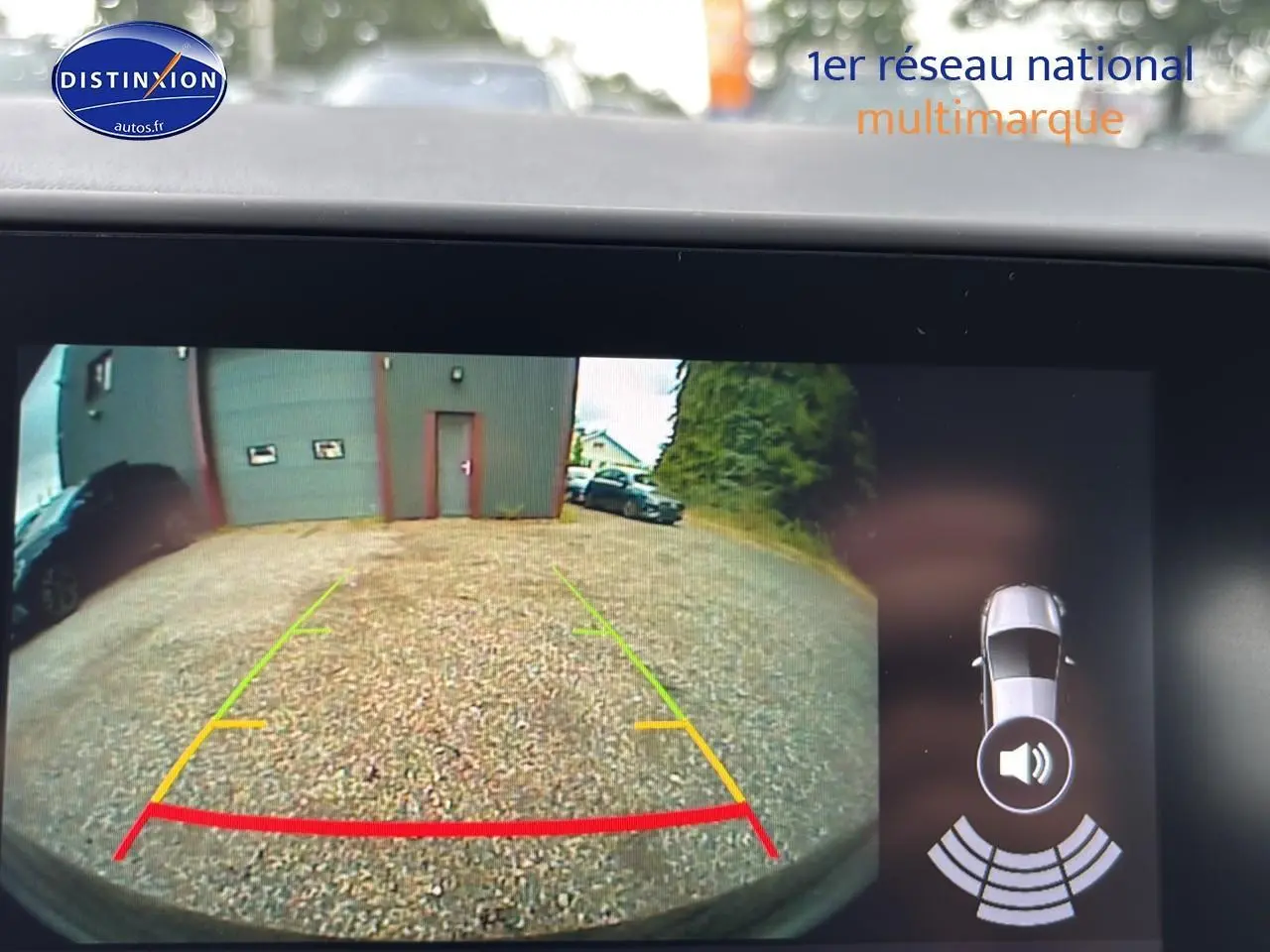 Vue caméra de recul de la Renault Clio V noire montrant l'arrière et l'espace de stationnement gravillonné.