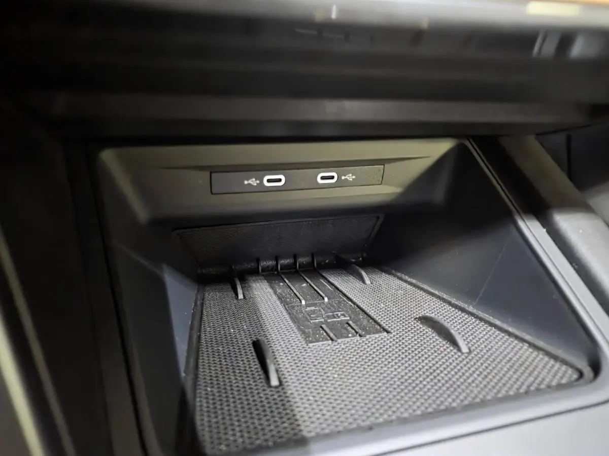 Gros plan sur la console centrale noire avec deux prises USB-C éclairées dans une CUPRA Leon gris 2025.