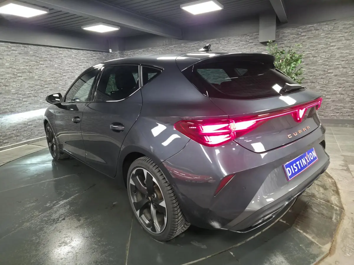 Vue 3/4 arrière droite d'une CUPRA Leon gris magnétique avec feux arrière Tri-LED et jantes alliage 18 pouces.