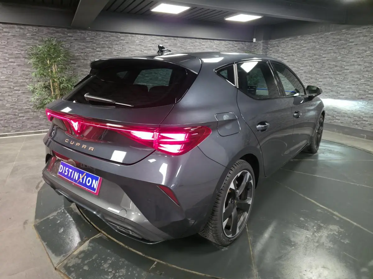 Vue 3/4 arrière droite d'une CUPRA Leon gris magnétique avec feux arrière Tri-LED et jantes alliage 18 pouces.