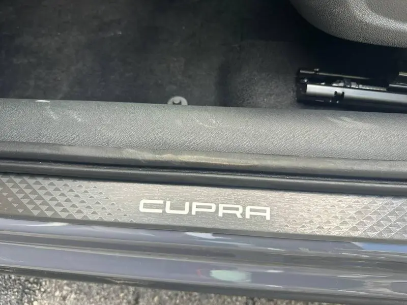 Gros plan sur la plaque de seuil de porte CUPRA avec finition Gris Graphène personnalisé visible en bas du cadre.