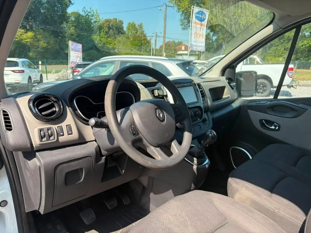 Vue intérieure côté conducteur du Renault Trafic Fourgon blanc de 2018, avec tableau de bord et volant visibles.