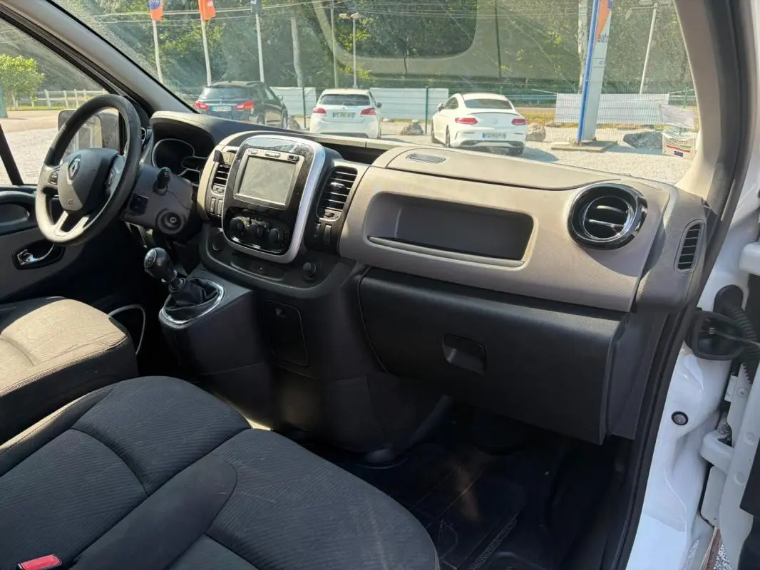 Intérieur du Renault Trafic Fourgon blanc 2018, vue côté passager montrant tableau de bord et volant à gauche.