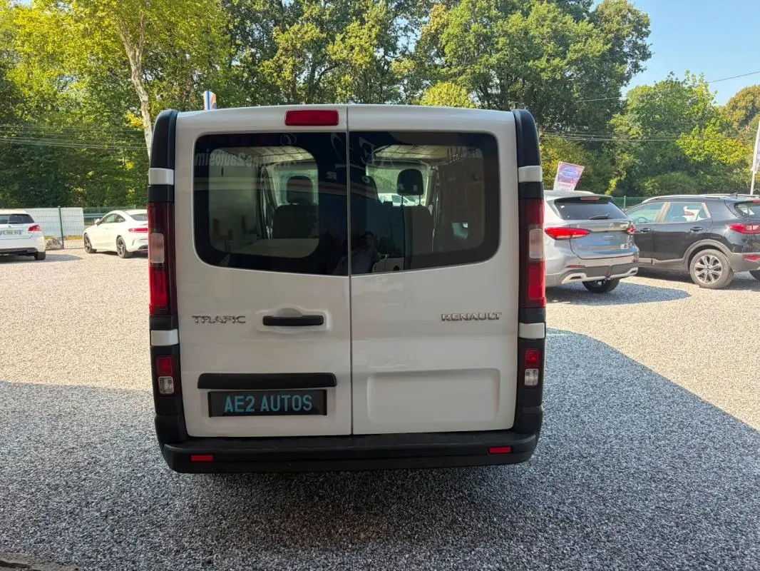 Vue arrière d’un Renault Trafic Fourgon blanc de 2018, avec portes battantes et vitres teintées.