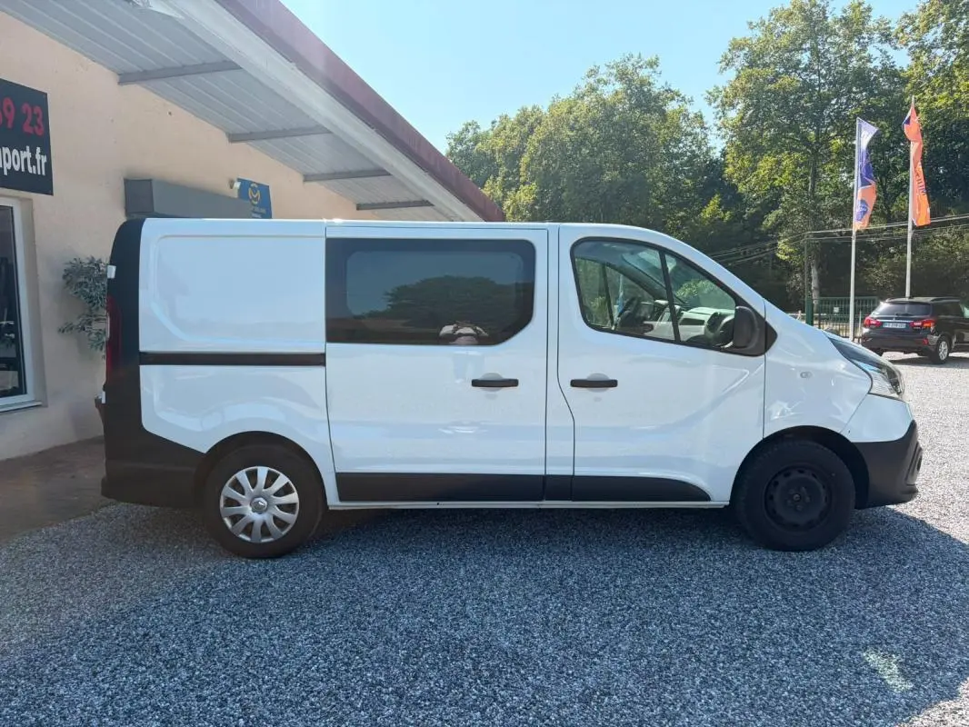 Profil droit du Renault Trafic Fourgon blanc de 2018, version Grand Confort L1H1, avec fenêtres latérales teintées.