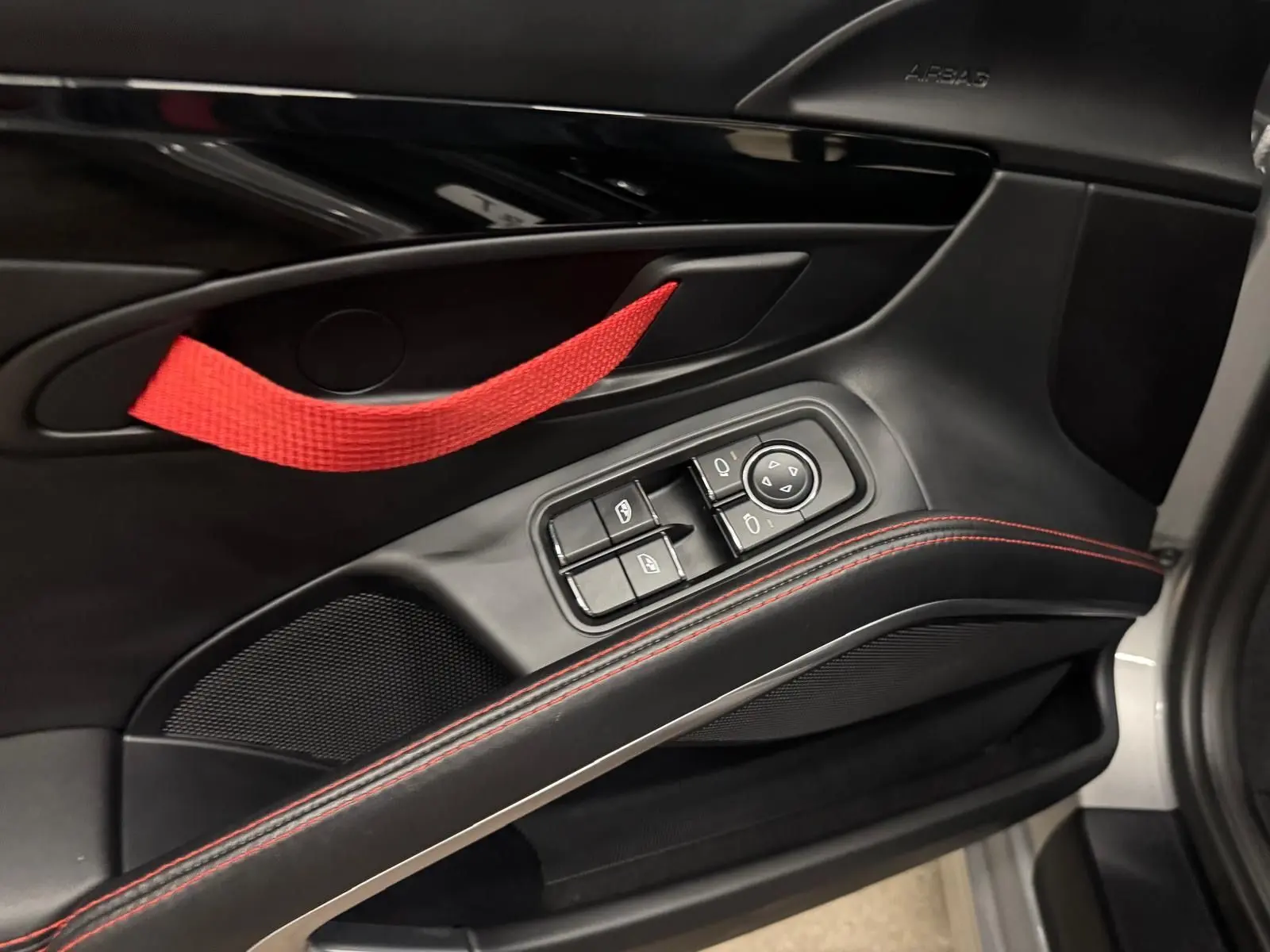 Détail de la porte côté conducteur de la Porsche 911 991 2 Carrera T gris GT Silver avec poignée rouge et surpiqûres rouges.