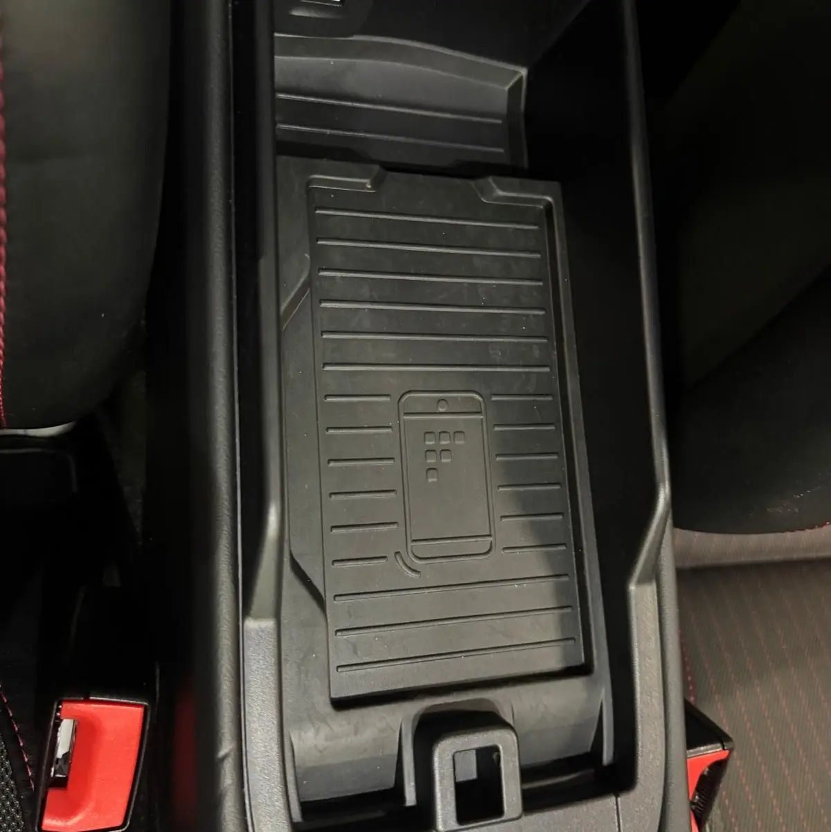 Vue plongeante sur la console centrale noire du Porsche 911 991 2 Carrera T avec porte-gobelet et port USB visible.