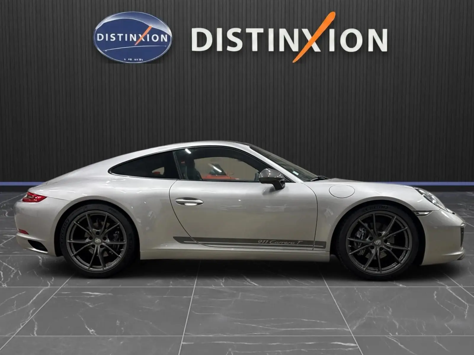 Porsche 911 991.2 Carrera T gris GT Silver vue profil droit, jantes Carrera S noires et bande latérale distinctive.
