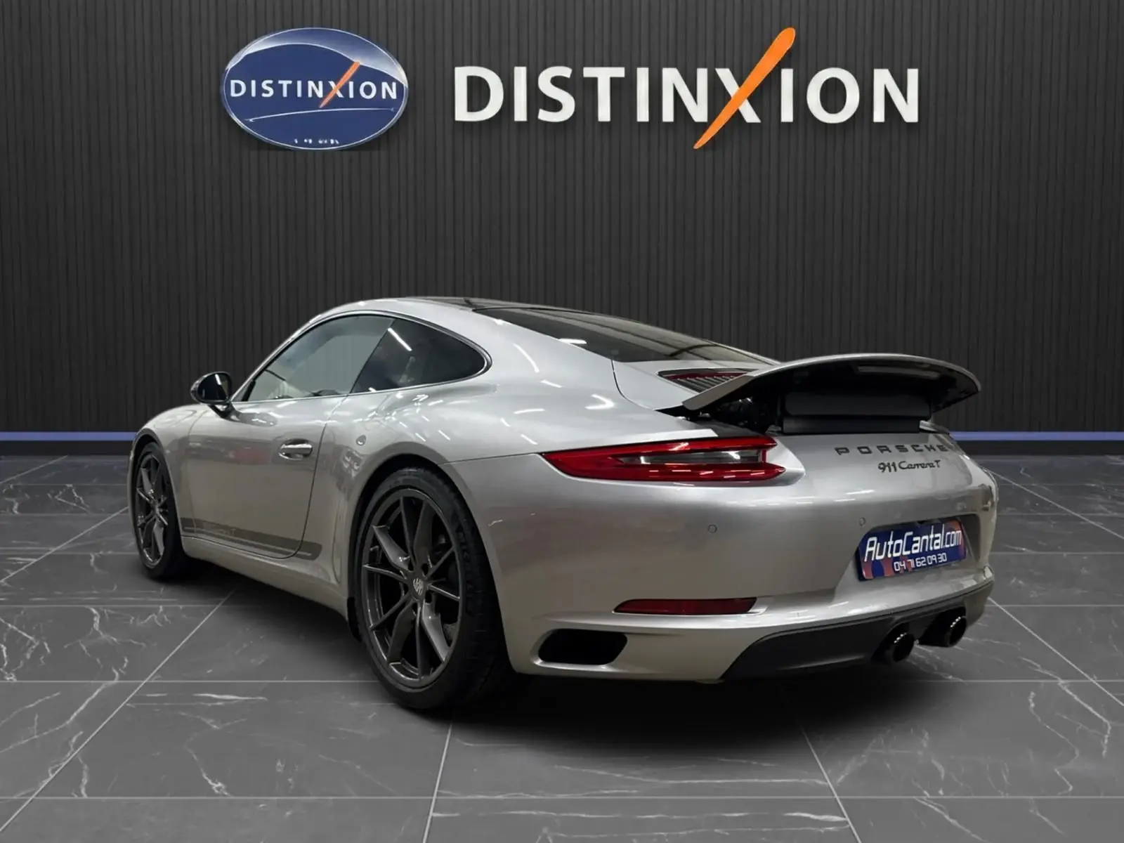 Vue 3/4 arrière droite d'une Porsche 911 Carrera T 2018 gris GT Silver avec aileron arrière déployé et jantes Carrera S 20 pouces.