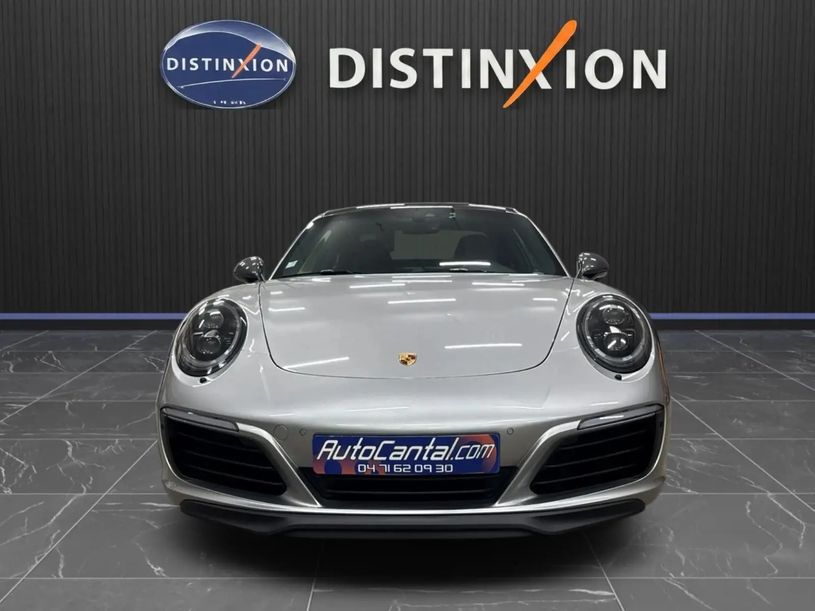 Vue frontale d'une Porsche 911 991 2 Carrera T 2018 en gris GT Silver, avec phares ronds et calandre noire.
