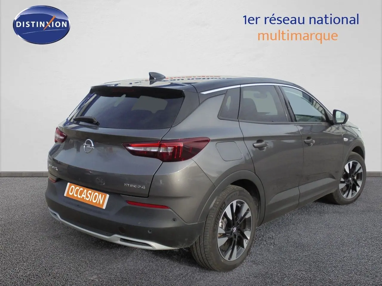 Vue 3/4 arrière droite de l'Opel Grandland X gris Moai Metal avec jantes noires et toit noir contrasté.