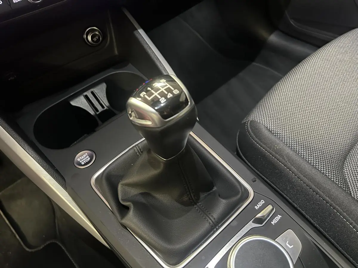 Gros plan sur levier de vitesses manuel noir et console centrale de l'Audi Q2 S line 2024.