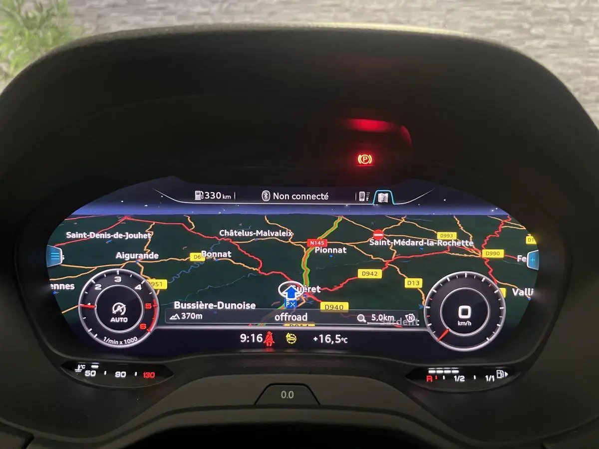 Affichage numérique du tableau de bord Audi Q2 2024 avec navigation et compte-tours, vue frontale rapprochée.