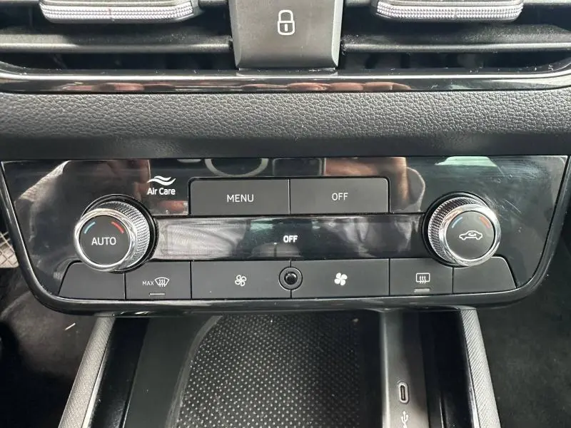 Vue rapprochée de la console centrale noire du Skoda Scala 2025, avec commandes de climatisation automatique et ventilation.