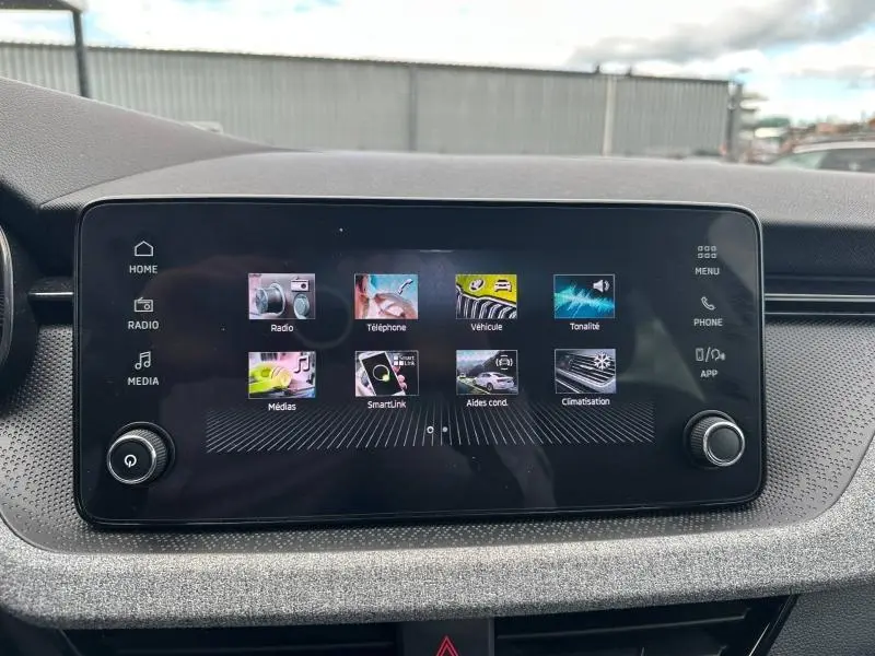 Écran tactile central du tableau de bord de la Skoda Scala gris graphite, affichant le menu multimédia.