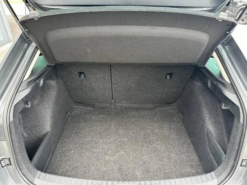 Coffre ouvert vu de l'arrière d'une Skoda Scala gris graphite métallisé, espace de chargement propre et spacieux.
