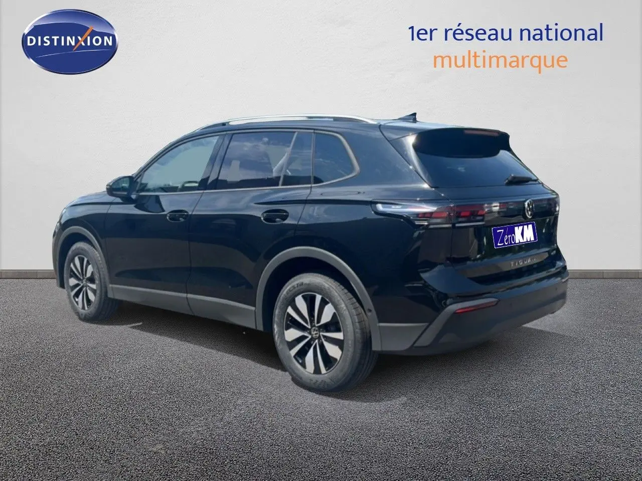 Volkswagen Tiguan noir grenadilla métal vu en 3/4 arrière côté droit, avec jantes alliage et toit argenté.
