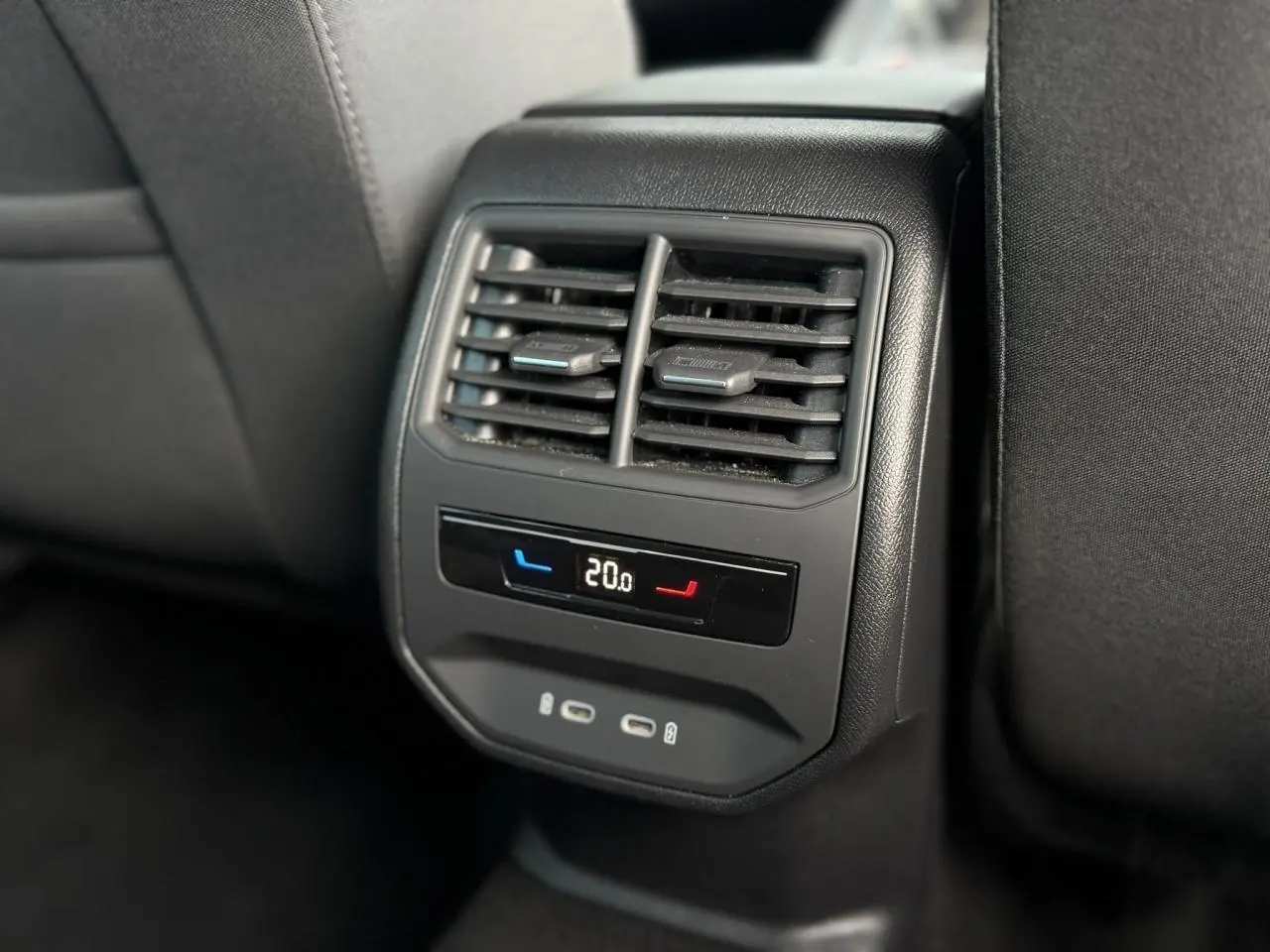 Vue rapprochée de la console arrière noire du SEAT LEON ST 1.5 TSI avec réglage climatisation et ports USB-C.